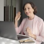 Medium shot smiley woman with laptop online angol tanulas